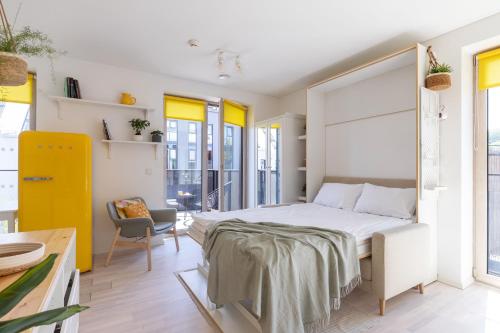 维尔纽斯Yellow Studio Paupys的一间卧室配有一张大床和一把椅子