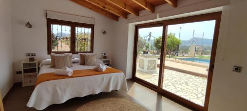 哈维亚Casa Rancho Grande的一间卧室设有一张床和一个大型滑动玻璃门