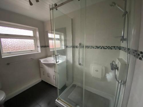 克利夫利斯Quiet secluded two bedroom bungalow with parking的一间带玻璃淋浴和水槽的浴室