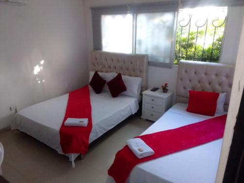 巴兰基亚buenavista class的卧室内的两张床,配有红色和白色床单