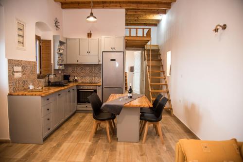 LakkíonMike's Guesthouse的厨房配有桌椅和冰箱。