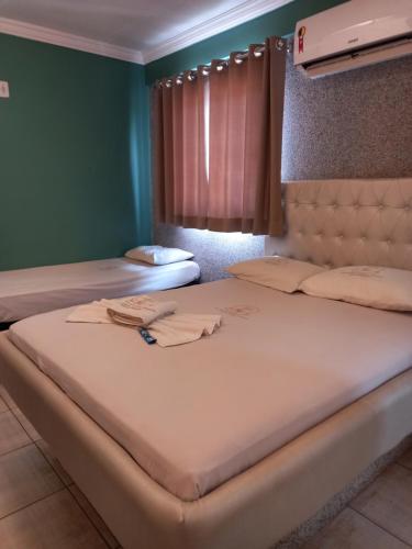 阿瓜斯克拉腊斯Hotel 1001 Prime Ade Águas Claras的绿墙客房内的两张床