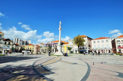 塞图巴尔Suites DP Setúbal的市中心一座广场,有一座纪念碑