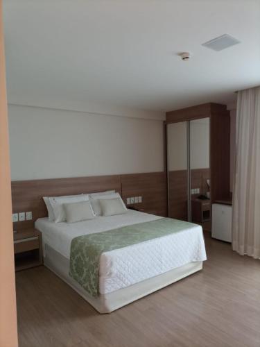 佩德拉阿祖尔Condomínio Vista Azul Hotel的一间卧室配有一张带白色床单的大床