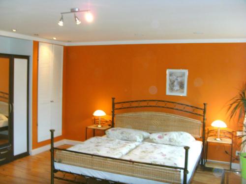 韦森贝格Ferienwohnung am Heegesee的一间卧室配有一张橙色墙壁的床