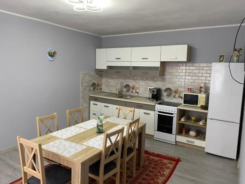 科伦德Anikó kulcsosház的厨房配有木桌和白色冰箱。