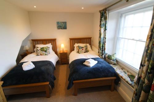 PenruddockSpringfield Farm, Penruddock的带窗户的客房内设有两张单人床。