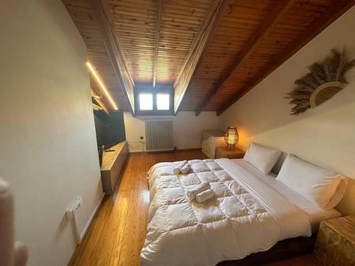 阿特米达Caja De Anthea的卧室配有一张白色大床和木制天花板