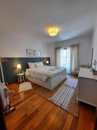 阿威罗Casa das Camélias的一间卧室设有一张大床,铺有木地板。