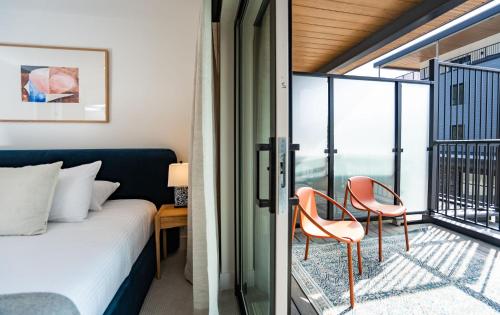 雷夫尔斯托克Sea Eagles Landing by Revelstoke Vacations的一间带一张床和两把椅子的卧室,位于阳台