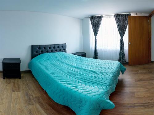 索加莫索Chalet Supérior con Jacuzzi interior ! 30 minutos gratis的一间卧室配有一张带绿色棉被的床