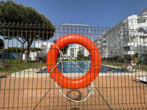 埃尔波提尔Cosy 2BR flat in Nuevo Portil city centre的游泳池里的一个橙色救生圈