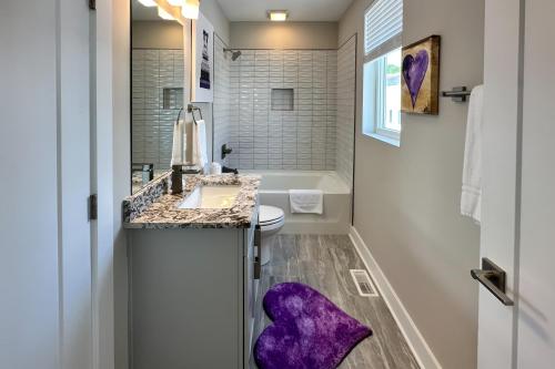 纳什维尔Stay GOODrich的浴室设有水槽,地板上铺有紫色地毯。