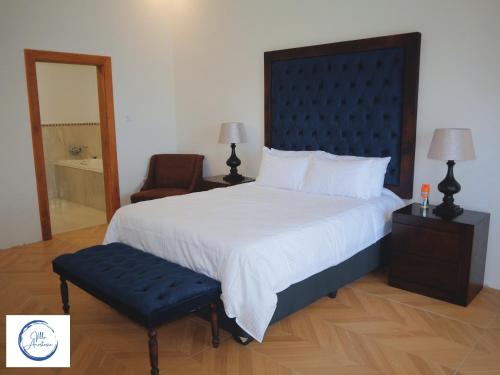 希亚丰加Villa Anastasia的一间卧室配有一张大床和一把椅子