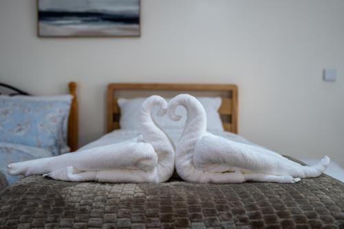 什鲁斯伯里Personal En-suite的两条毛巾放好,看起来像天鹅在床上