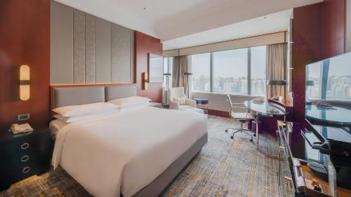 上海上海雅居乐万豪侯爵酒店的卧室配有一张白色大床、一张书桌和一张书桌