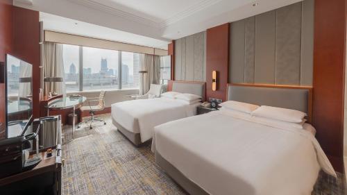上海上海雅居乐万豪侯爵酒店的酒店客房设有两张床和电视。