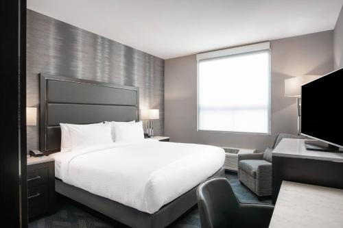 切尔西Fairfield Inn & Suites by Marriott Boston Logan Airport/Chelsea的酒店客房,配有床和电视