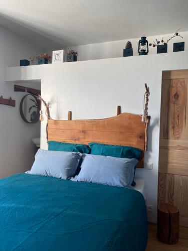勒奥瓦尔德La Vieille Eglise的一间卧室配有一张蓝色的床和木制床头板