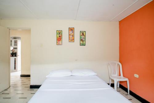 巴兰基亚HABITACION PRIVADA EN CASA DE MIS PADRES的卧室配有白色的床和椅子