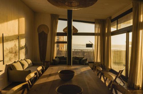皮奇勒姆Casas Punta Costanera的客厅设有桌子和大窗户