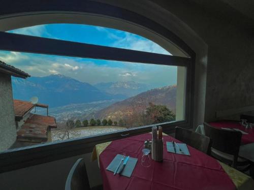 GratacasoloOsteria Carli B&B的一张桌子,从窗户可欣赏到山景