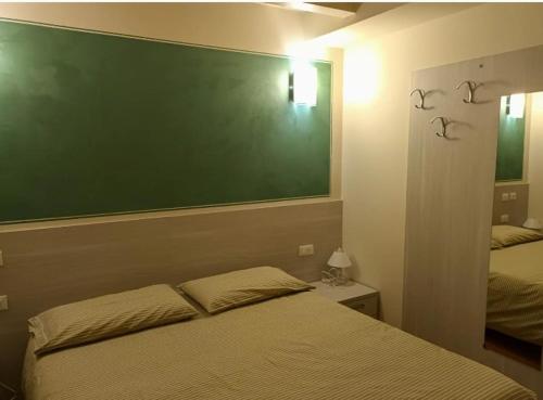 GratacasoloOsteria Carli B&B的卧室位于床上方,设有绿板