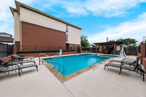 Lake Dallas达拉斯湖贝斯特韦斯特酒店的一座带两把椅子的游泳池位于大楼旁