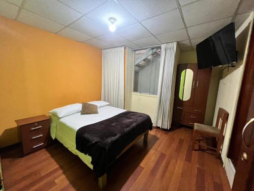 阿雷基帕OROSHEAM的一间卧室配有一张床和一台平面电视