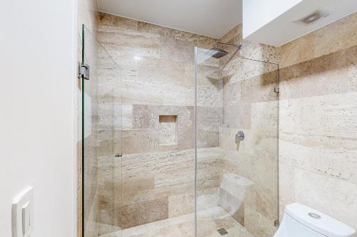 普拉亚卡门Menesse Midtown 2 Unit 208的浴室设有玻璃淋浴间和卫生间