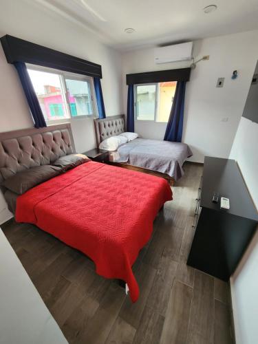 Cunduacánhabitaciones disponibles con baño privado zona centro的一间卧室配有两张床和红色毯子