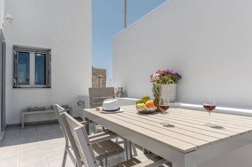 纳克索乔拉Villa Nektar, Luxury Apartment in Chora Naxos的一张桌子,上面放着两杯葡萄酒和一碗水果