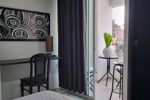布卡拉曼加Ardival apartment - WAIWA HOST的卧室设有窗户、桌子和椅子