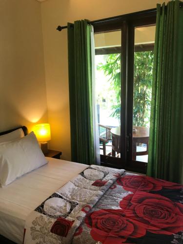 乌布Werkudara Guest House的一间卧室设有一张床和一个带庭院的窗户。