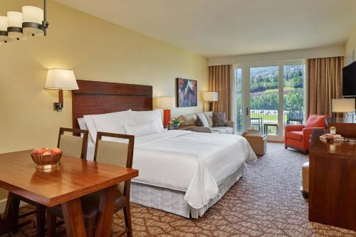 埃文The Westin Riverfront Mountain Villas, Beaver Creek Mountain的酒店客房设有一张大床、一张桌子和一张桌子。