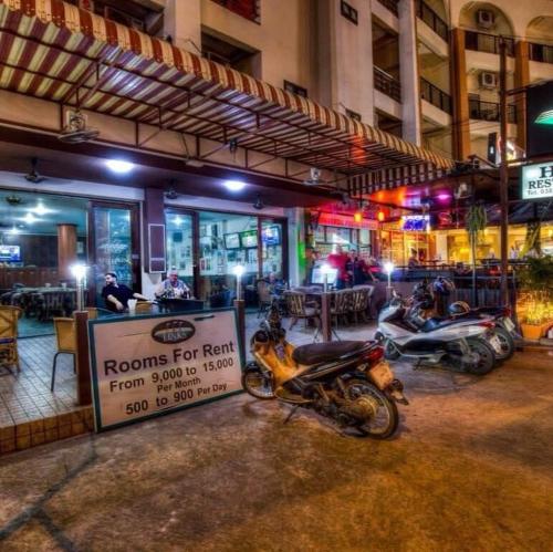 芭堤雅市中心the links hotel的一排停在餐厅前面的摩托车