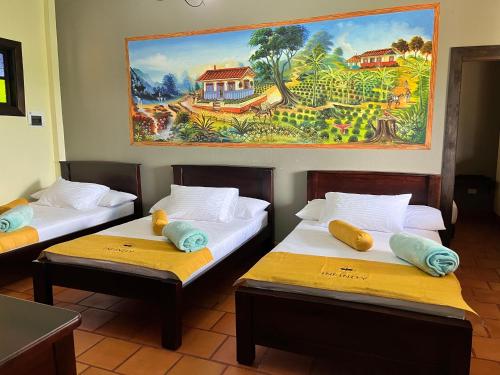 金巴亚Hotel Campestre Los Mangos的墙上画画的房间里设有两张床