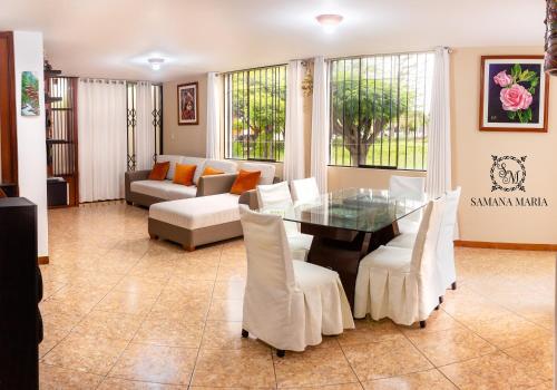 阿雷基帕SSAMANA MARÍA APARTMENT 102的客厅配有玻璃桌和白色椅子