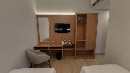 泗水AYMAN SYARIAH HOTEL的客房设有一张带电视和镜子的书桌。