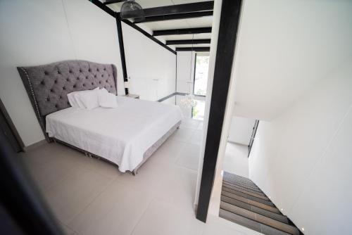 hermosa cabaña multinivel para pareja的卧室配有白色的床和椅子
