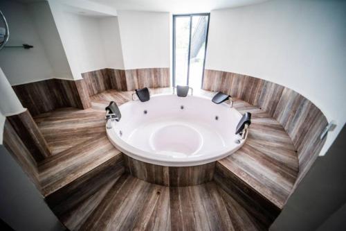 luxury suite presidencial的铺有木地板的客房内设有一个大浴缸