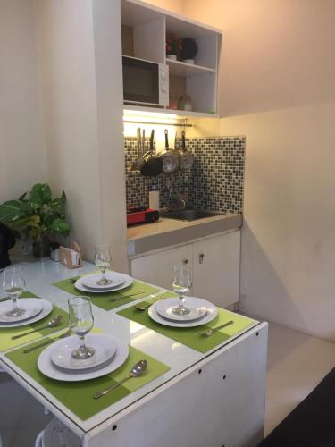 岩望House at Taman Dayu的厨房配有带盘子和玻璃杯的桌子