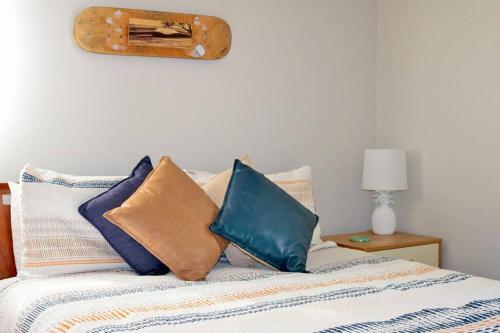 波因特卢考特Sand Dweller Holiday Villa Point Lookout的床上有色彩缤纷的枕头