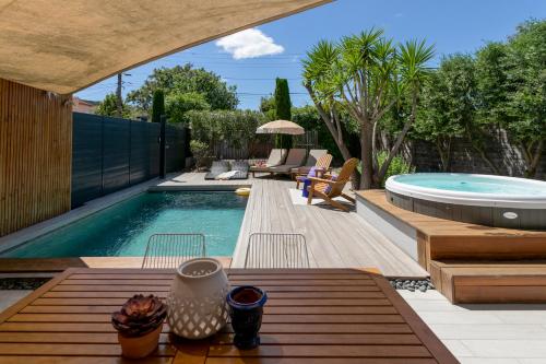 塞特港Villas les Capucines的后院设有游泳池以及带椅子和桌子的庭院。