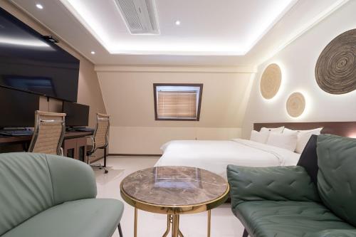 忠州市From H Chung-ju About Hotel的酒店客房带一张床、一张桌子和椅子