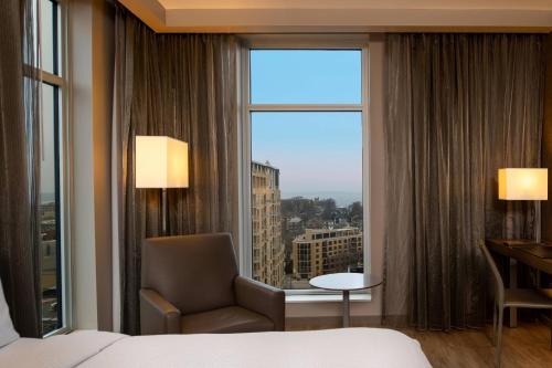 麦迪逊AC Hotel by Marriott Madison Downtown的酒店的客房 - 带一张床、椅子和窗户