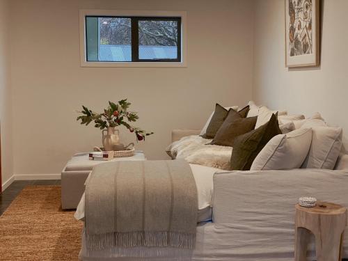 瓦纳卡Wanaka Deluxe Studio的客厅配有白色的沙发和桌子