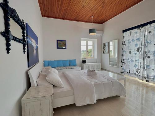 斯派赛斯Villa Ancora Spetses的一间卧室配有一张大床和蓝色床头板