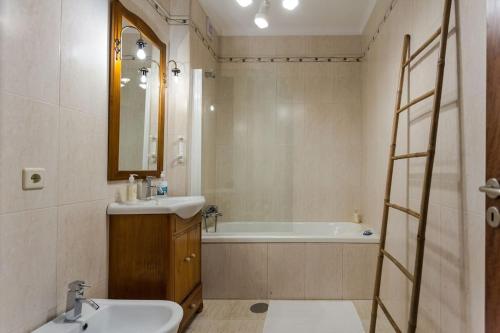 拉布鲁吉480 Liberdade Apartamento的浴室配有盥洗盆和浴缸。