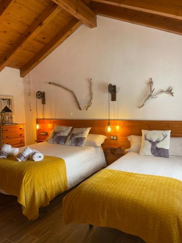 里亚尔普DUPLEX ALPINO的墙上有鹿头的房间的两张床